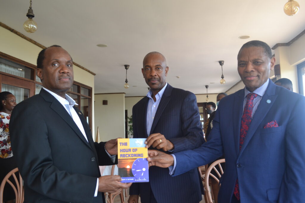 DR.ROBERT RUTAAGI NATIONAL PRESIDENT FGBMFI UGANDA DONATES HIS LATEST BOOK ABOUT HIS TESTIMONY WITH HIS SALVATION CALLED "THE HOUR OF RECKONING" TO THE POPULAR ENTREPRENUER DR. PATRICK BITATURE CEO SIMBA GROUP OF CAMPANIES AT THE PRAYER BREAKFAST MEETING.